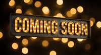 Illuminated coming soon sign with warm golden bokeh lights creating anticipation for upcoming events, product launches, and business announcements.