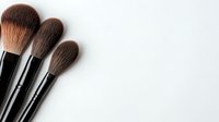 Professional makeup brushes arranged diagonally on white background, soft natural bristles in brown tones, clean minimal composition for beauty and cosmetics industry.
