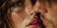 Close-up portrait of young woman with freckles and wet skin showing intimate moment with male partner in warm golden lighting for romantic concepts.
