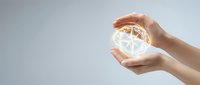 Hands protecting glowing globe with network connections symbolizing global communication, environmental protection and worldwide connectivity.