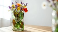 Colorful wildflower bouquet in glass mason jar on wooden table with soft natural lighting and blurred background for home decor and lifestyle concepts.