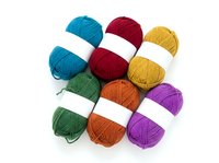 Colorful yarn balls arranged in circle on white background, isolated knitting and crochet supplies for craft projects, textile arts, and handmade design work.