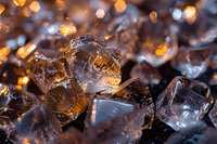Macro shot of transparent ice crystals with golden bokeh lights creating magical winter atmosphere. Natural frozen water formations in cold weather.