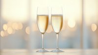 Two elegant champagne flutes filled with sparkling wine against soft bokeh background, romantic celebration atmosphere with golden bubbles and blurred lights.