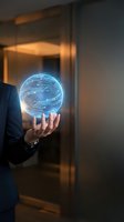 Businessman in dark suit holding glowing blue digital sphere with circuit board patterns, representing technology innovation and artificial intelligence solutions for business concepts.