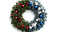 Festive holiday wreath with red, blue, and white ornaments on green and frosted pine branches, creating a patriotic color scheme for seasonal home decoration.