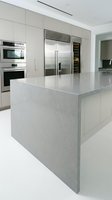 Modern luxury kitchen with white cabinetry, marble island countertop, stainless steel appliances and refrigerator. Interior design for home renovation, real estate and kitchen remodeling projects.