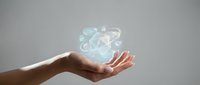 Open palm holding glowing holographic recycling symbol with light effects against neutral background for environmental sustainability concepts.