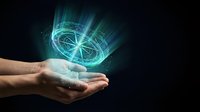 Hands holding glowing holographic compass with light rays on dark background for navigation and direction concepts in business and technology applications.