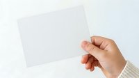 Hand holding blank white card or paper against neutral background, suitable for business presentations, marketing mockups, and promotional designs.