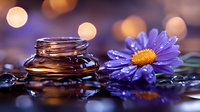 Purple daisy with water drops next to massage stones on dark reflective surface with golden bokeh lights creating spa atmosphere and wellness concept.