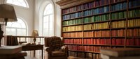 Elegant home library with floor-to-ceiling rainbow bookshelf, vintage armchair and wooden desk near arched windows for reading and study space.