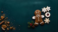 Gingerbread man cookie with white icing smile and buttons next to star-shaped cookies and festive decorations on teal background for holiday baking and seasonal celebrations.