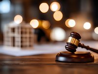 Wooden judge gavel on sound block against blurred bokeh lights background, with legal documents. Conceptual law and justice composition.