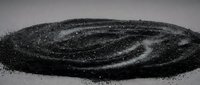 Black sand or powder forming spiral galaxy pattern on white surface for cosmic astronomy educational materials and space science presentations.