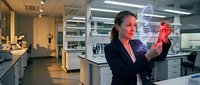 Female scientist in a lab examines a glowing red DNA hologram, merging biotechnology with modern medical research in a futuristic setting.