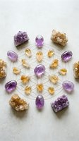 Sacred geometry crystal grid with amethyst and citrine gemstones arranged in flower of life pattern for spiritual healing and meditation practices.