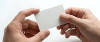 Hands holding blank white business card mockup for branding and corporate identity design projects on clean background.