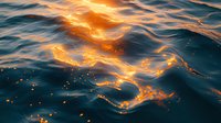 Mesmerizing ocean waves reflect golden sunset light creating magical ripples and sparkles on dark blue water surface, nature abstract background.