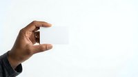 Male hand with medium-dark skin tone holding small blank card or object against white background, suitable for mockups, business presentations, and advertising campaigns.