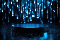 Empty round podium with blue glowing lights falling from above, creating magical atmosphere on dark background with reflective surface and sparkles.