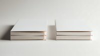 Minimalist composition of blank white hardcover books arranged in two neat stacks on neutral background, perfect for publishing or literature concepts.