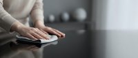Woman hands cleaning modern kitchen counter with cloth in contemporary home interior for hygiene and household maintenance tasks.