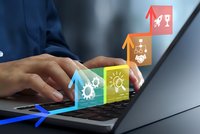 Business professional using laptop with colorful digital icons representing innovation, teamwork, ideas and growth emerging from screen for technology concepts.