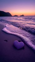 Purple heart shape on sandy beach at romantic sunset with gentle waves and mountain silhouettes creating dreamy coastal atmosphere for love concepts.