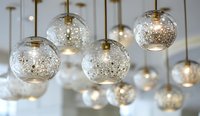 Elegant glass globe pendant lights with sparkling silver accents hanging from brass fixtures, creating a luxurious atmosphere for modern interior design.