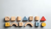 Colorful wooden toy blocks with letters and numbers arranged on white background for educational play and learning activities.