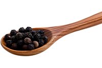 Dried juniper berries on wooden spoon isolated on white background, aromatic spice used in cooking and gin production, natural food ingredient.