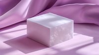 White soap bar casting soft shadow on pink silk fabric background with gentle folds, creating minimalist spa composition for beauty and wellness concept.