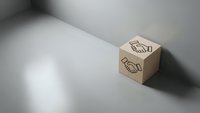 Wooden cube with handshake symbol on white surface with dramatic shadows. Business partnership and agreement concept for corporate branding materials.