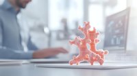 Coral-inspired decorative figurine on laptop with businessman working in background office environment. Perfect for marine-themed workspace decor.