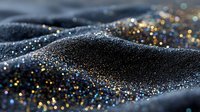 Luxurious black fabric with golden glitter particles creating elegant waves and texture for fashion or festive background design.