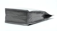 Matte gray flat bottom pouch lying on its side on white background, showcasing modern flexible packaging design for coffee, tea, or snacks.