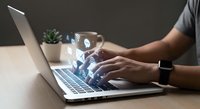 Professional man typing on laptop with digital communication icons floating above keyboard representing modern technology and connectivity.