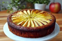 Homemade apple cake with decorative sliced fruit pattern on wooden kitchen counter. Fresh baked dessert for cafes, bakeries and food blogs.