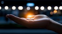 Open palm holding glowing light against blurred bokeh background, creating magical atmosphere with soft illumination and dreamy evening ambiance.