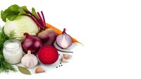 Fresh organic vegetables including beetroot, cabbage, carrots, onions and garlic with milk glass isolated on white background for healthy cooking recipes.
