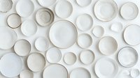 White ceramic plates and bowls collection arranged on clean background showcasing various sizes and shapes for kitchen dining tableware design projects.