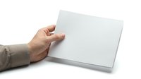 Hand holding blank white envelope on white background isolated for mockup design and mailing correspondence concepts.