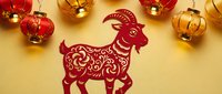 Red paper cut goat zodiac symbol with golden lanterns for Chinese New Year celebration and traditional festival decoration on warm background.