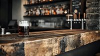 Glass of whiskey on wooden bar counter with blurred bottles and shelves in background, suitable for hospitality, restaurant, and beverage industry marketing materials.