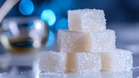 White sugar cubes stacked in pyramid shape with sparkling crystals and blue bokeh lights in background, macro food photography for healthy lifestyle concepts.