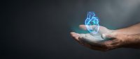 Human hands holding glowing blue holographic heart with digital wireframe design against dark background for medical technology concepts.