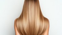 Long straight blonde hair from back view on white background, showing healthy smooth shiny hairstyle with natural highlights and ombre coloring technique.