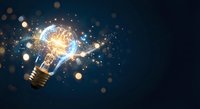Glowing light bulb with brain inside surrounded by sparkling particles and bokeh lights on dark background representing innovation and creative thinking.