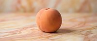 Fresh apricot on marble surface with warm lighting, suitable for food photography, culinary content, and healthy eating designs.